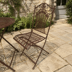 Detalle de las sillas plegables de metal marrón con respaldo decorativo