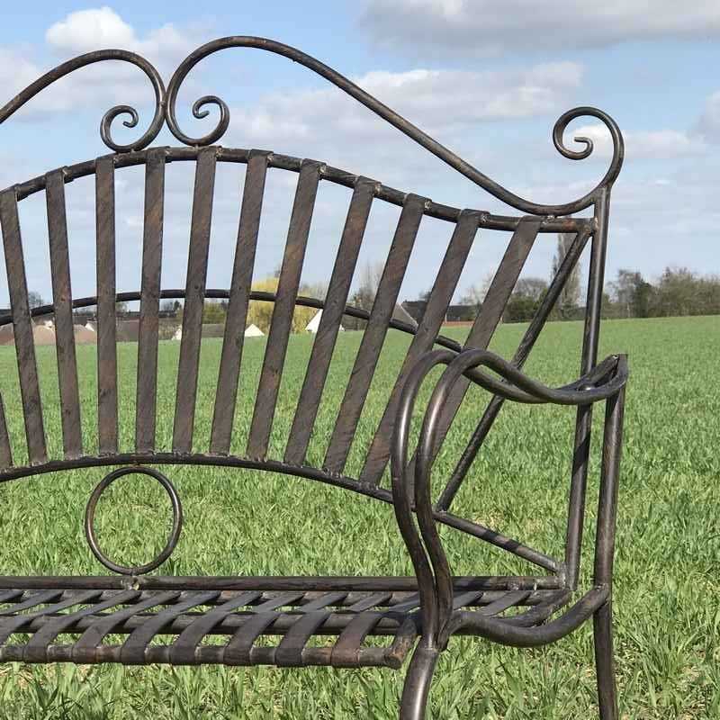 Banco de jardín de hierro forjado con arabescos, vista de cerca