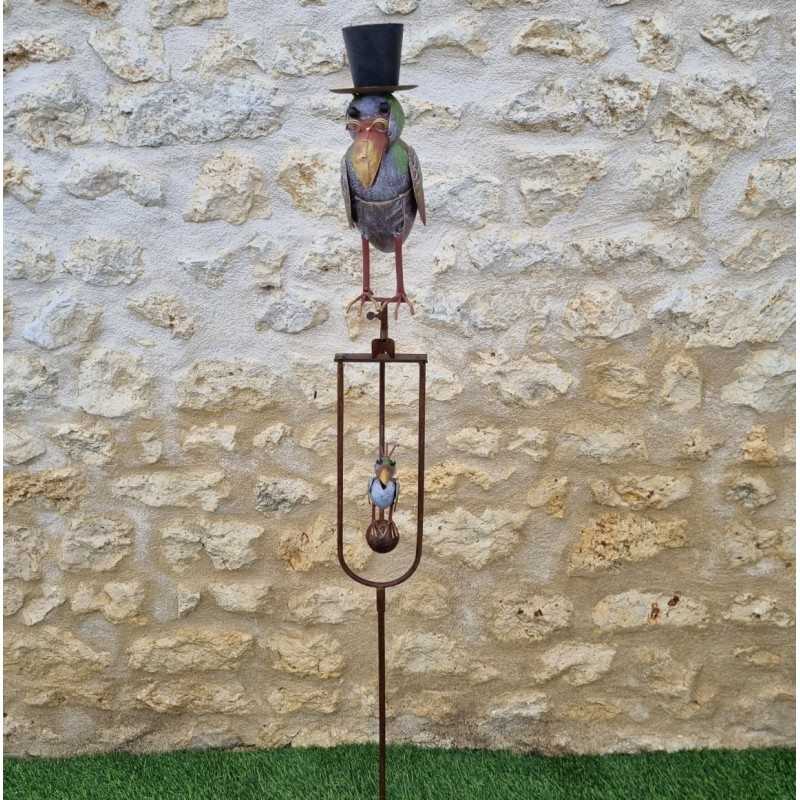 Cuervo de metal con sombrero sobre balancín de jardín