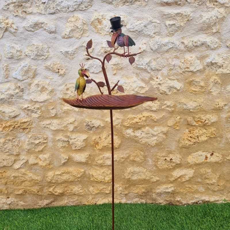 Bebedero y comedero para aves instalado en un jardín con flores