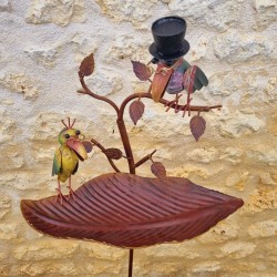 Detalle de pájaros decorativos de colores en cuenco de hierro fundido