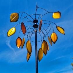 Molino de viento decorativo instalado en jardín con movimiento natural