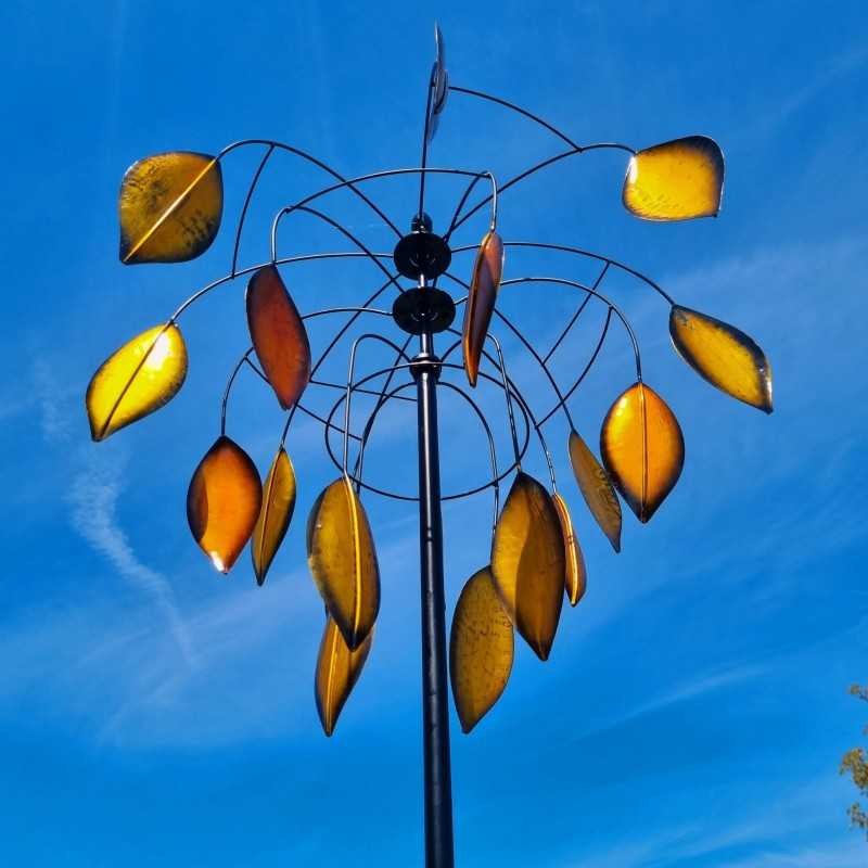 Molino de viento decorativo instalado en jardín con movimiento natural