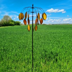 Molino de viento decorativo instalado en jardín con movimiento natural