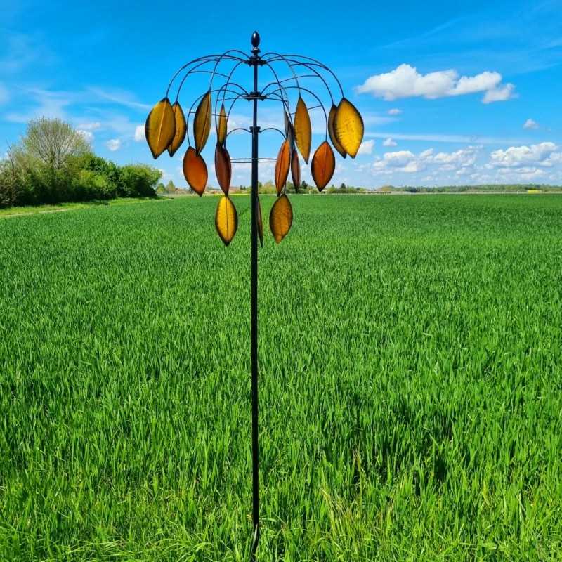 Molino de viento decorativo instalado en jardín con movimiento natural