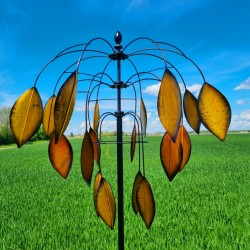 Molino de viento decorativo instalado en jardín con movimiento natural