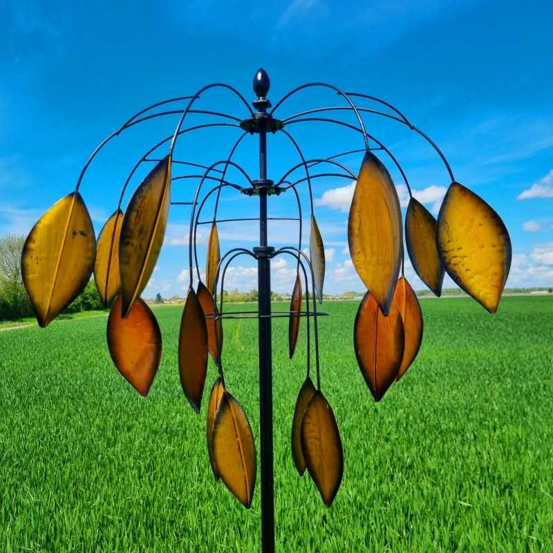 Molino de viento decorativo instalado en jardín con movimiento natural