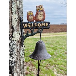 Campana decorativa con búhos instalada junto a una entrada