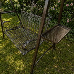 Columpio de metal instalado en un jardín romántico