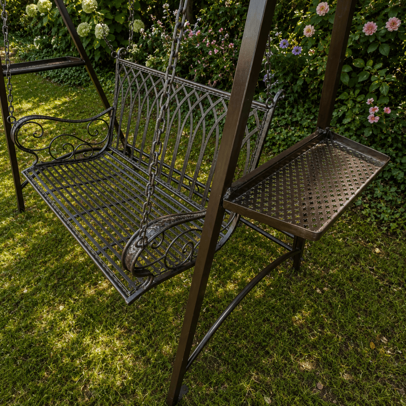 Columpio de metal instalado en un jardín romántico