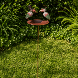 Comedero y baño para pájaros sobre estaca instalado en el jardín