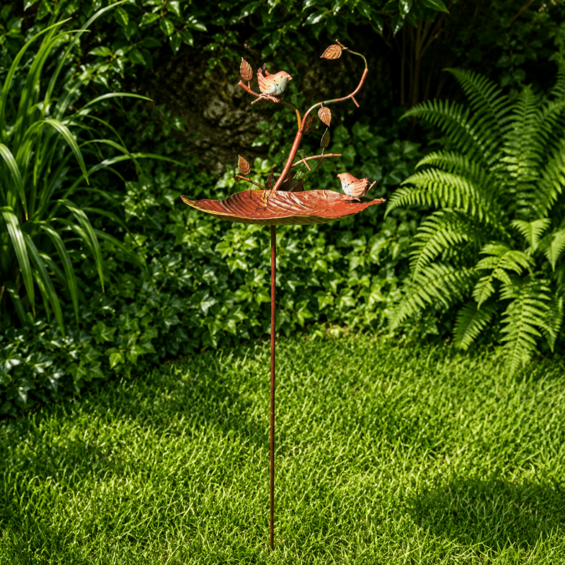 Comedero y bebedero para aves instalado en un jardín natural