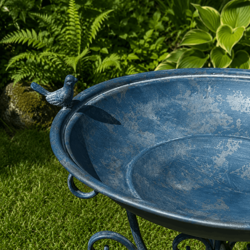 Trípode de metal azul con arabescos decorativos – Detalle