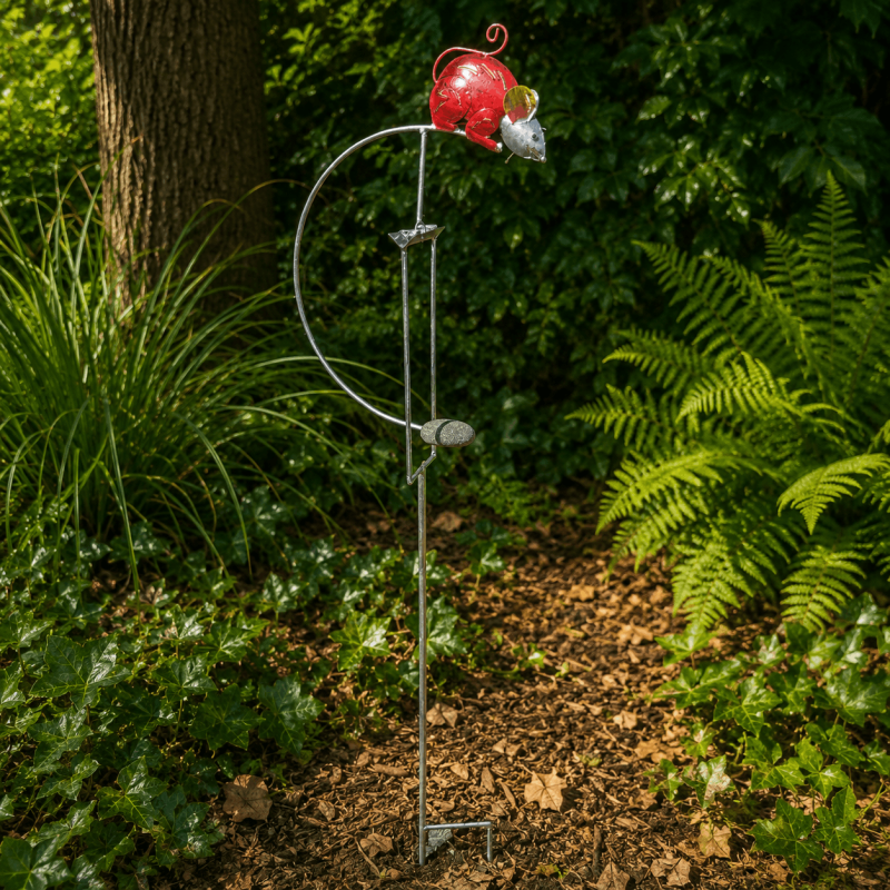 Móvil con ratón rojo instalado en un jardín natural