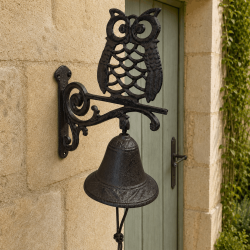 Campana mural con búho instalada junto a una puerta